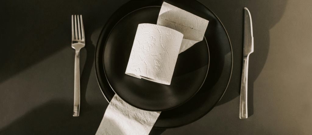 Illustration d'art conceptuel absurde : rouleau de papier toilette dans une assiette avec couverts